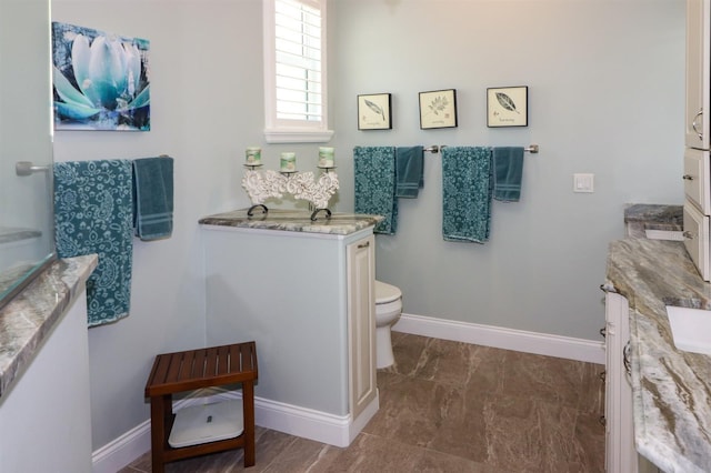 bathroom featuring marble finish floor, baseboards, toilet, and vanity