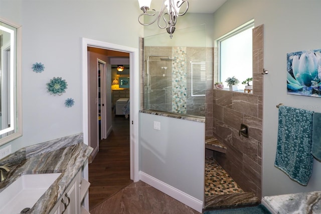 full bath with a chandelier, wood finished floors, vanity, and a walk in shower