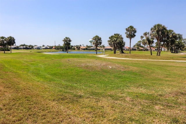 view of property's community with a yard, a residential view, a water view, and view of golf course