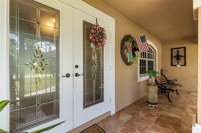 property entrance featuring french doors and stucco siding