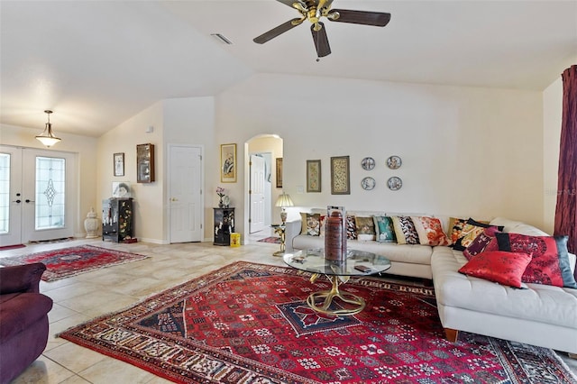 tiled living room with visible vents, arched walkways, a ceiling fan, vaulted ceiling, and french doors
