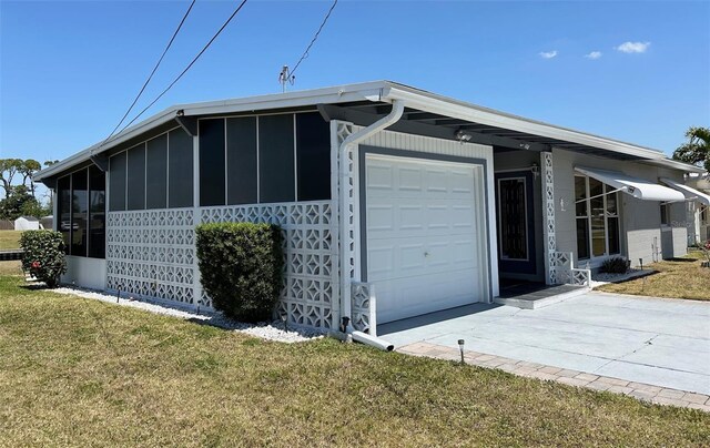 123 Poinsettia Cir NE, Port Charlotte, FL 33952 - view of home's exterior with board and batten siding, a sunroom, an attached garage, a lawn, and concrete driveway
