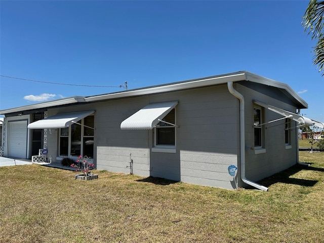123 Poinsettia Cir NE, Port Charlotte, FL 33952 - view of home's exterior featuring a yard, concrete block siding, and a garage