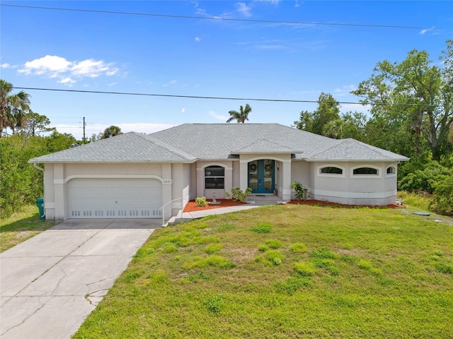 ranch-style house featuring a front yard, a garage, stucco siding, french doors, and driveway