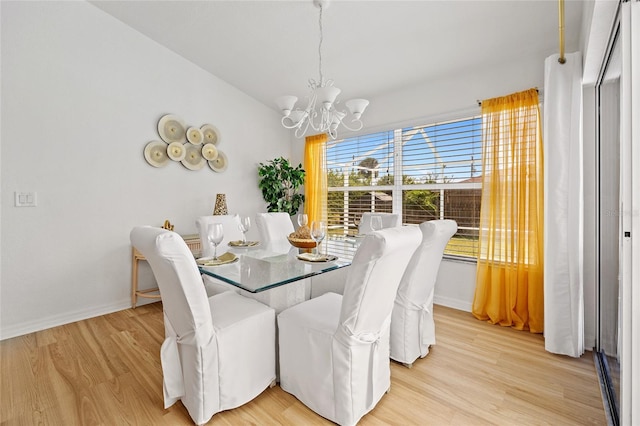 dining area featuring baseboards, a notable chandelier, and light wood-style floors