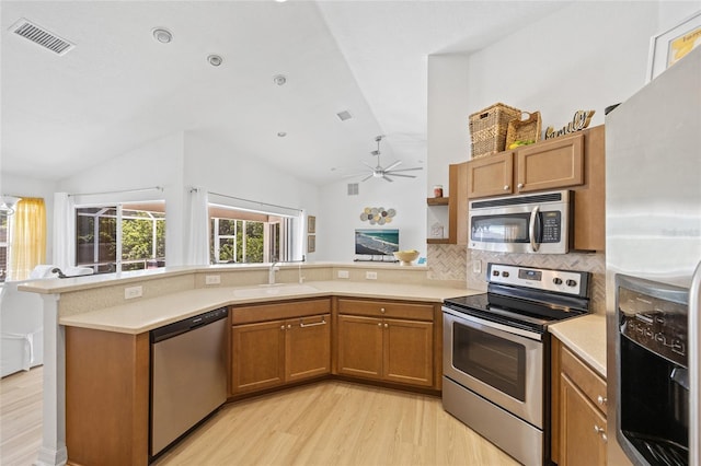 kitchen featuring a sink, visible vents, lofted ceiling, and stainless steel appliances