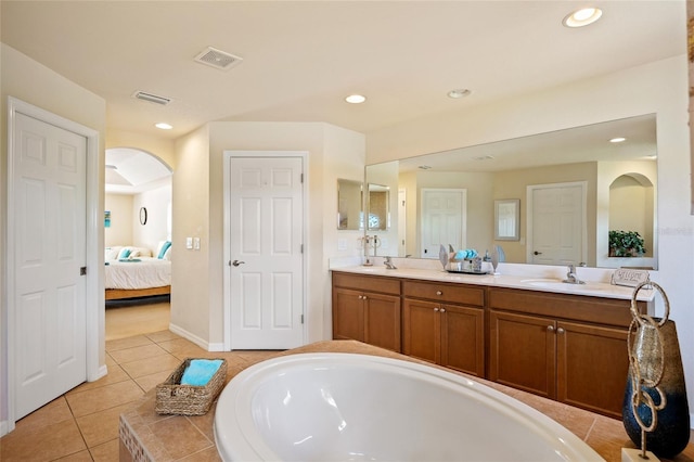 ensuite bathroom featuring a sink, visible vents, double vanity, and ensuite bath