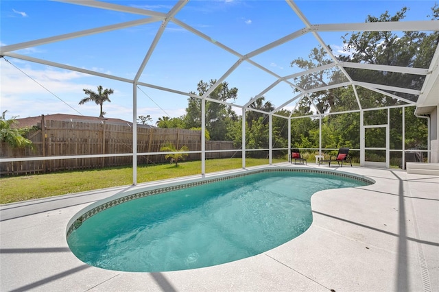 view of pool with a fenced backyard, a fenced in pool, a patio area, and glass enclosure