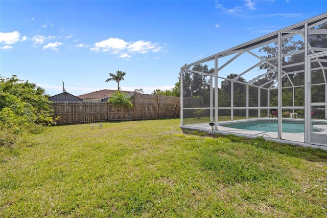 view of yard featuring a fenced in pool, a fenced backyard, and a lanai