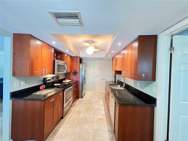 931 Juno Dr, Punta Gorda, FL 33950 - kitchen featuring appliances with stainless steel finishes, a tray ceiling, a ceiling fan, light tile patterned floors, and dark stone counters