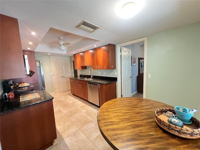 931 Juno Dr, Punta Gorda, FL 33950 - kitchen with stainless steel dishwasher, stove, a tray ceiling, a ceiling fan, and brown cabinetry