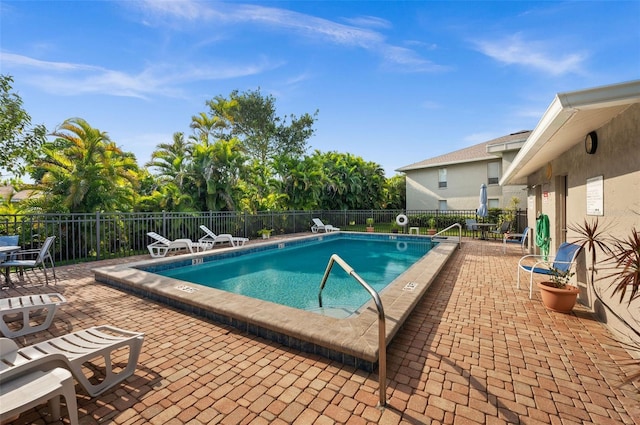pool featuring fence and a patio area