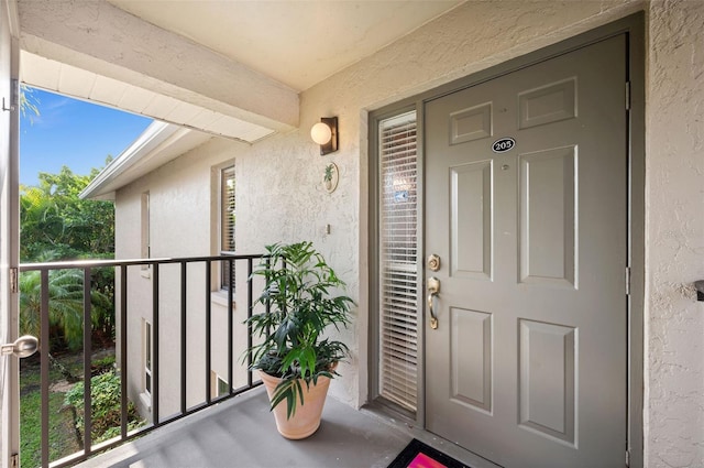 doorway to property featuring stucco siding