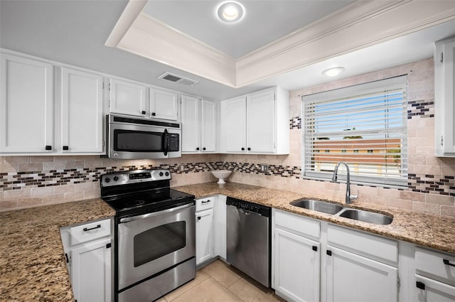 kitchen with decorative backsplash, crown molding, stainless steel appliances, a raised ceiling, and a sink