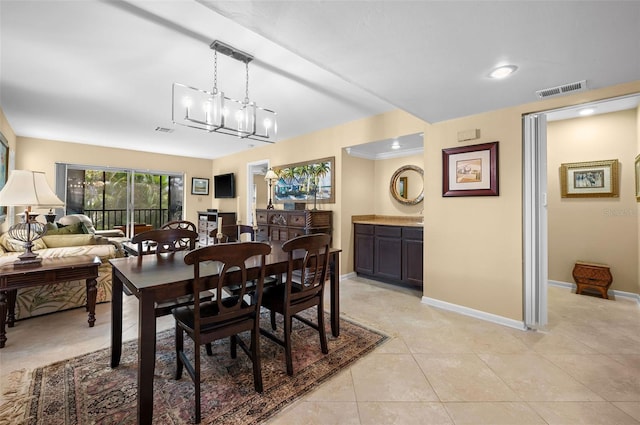 dining area featuring light tile patterned floors, a notable chandelier, baseboards, and visible vents