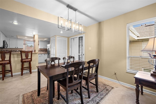 dining room featuring baseboards and light tile patterned floors