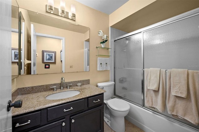 full bath with tile patterned floors, shower / bath combination with glass door, toilet, and vanity