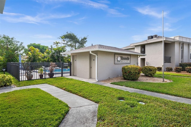 view of home's exterior with a fenced in pool, fence, stucco siding, and a yard