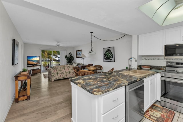 12274 SW Egret Cir Unit 2607, Lake Suzy, FL 34269 - kitchen featuring appliances with stainless steel finishes, a sink, open floor plan, a peninsula, and white cabinetry