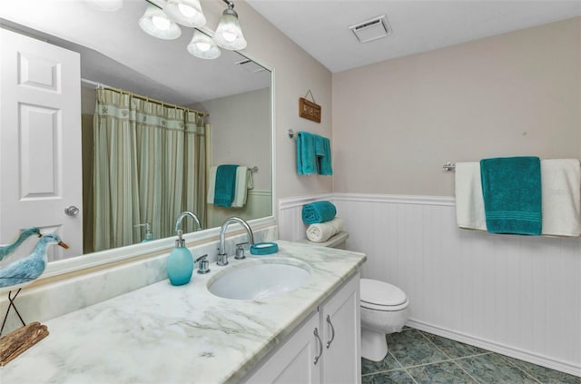 12274 SW Egret Cir Unit 2607, Lake Suzy, FL 34269 - full bath featuring vanity, toilet, a wainscoted wall, tile patterned floors, and a shower with shower curtain