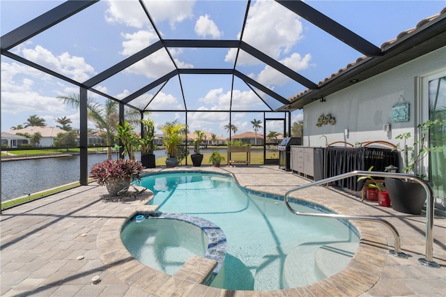 view of swimming pool with a patio, a water view, a pool with connected hot tub, and area for grilling