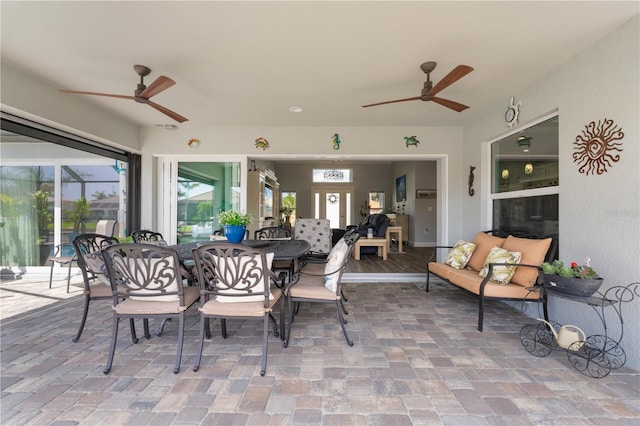 view of patio with outdoor dining space, a lanai, and ceiling fan