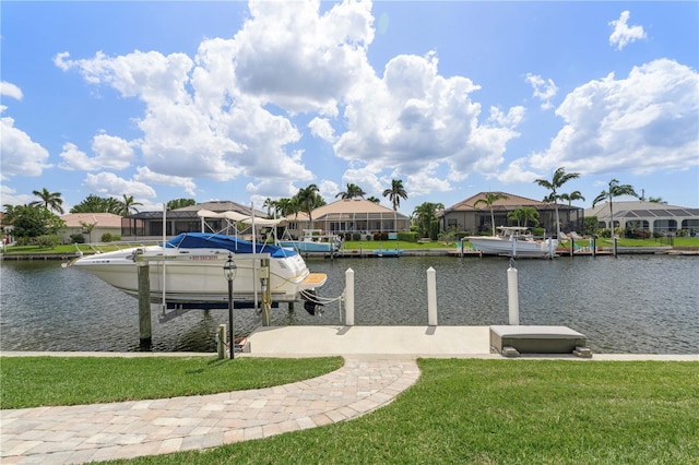 dock area featuring a water view, a residential view, boat lift, and a yard