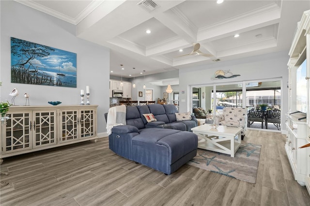 living area featuring coffered ceiling, visible vents, wood finished floors, and ornamental molding