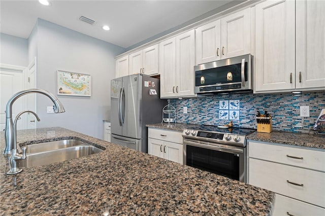 kitchen with visible vents, a sink, tasteful backsplash, and appliances with stainless steel finishes