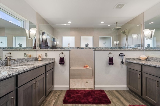 full bathroom with vanity, walk in shower, wood tiled floor, visible vents, and recessed lighting