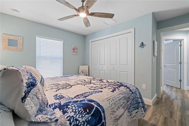 bedroom with baseboards, a closet, wood finished floors, and ceiling fan