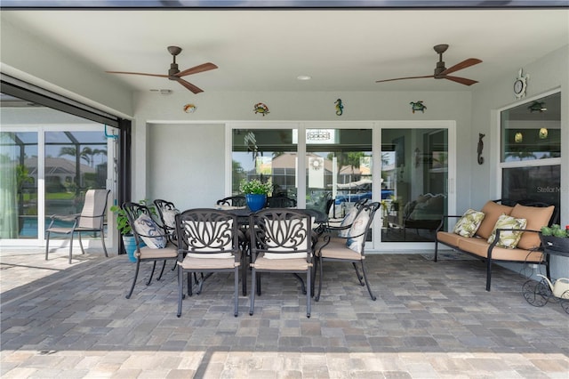view of patio / terrace featuring outdoor dining space, a lanai, and ceiling fan