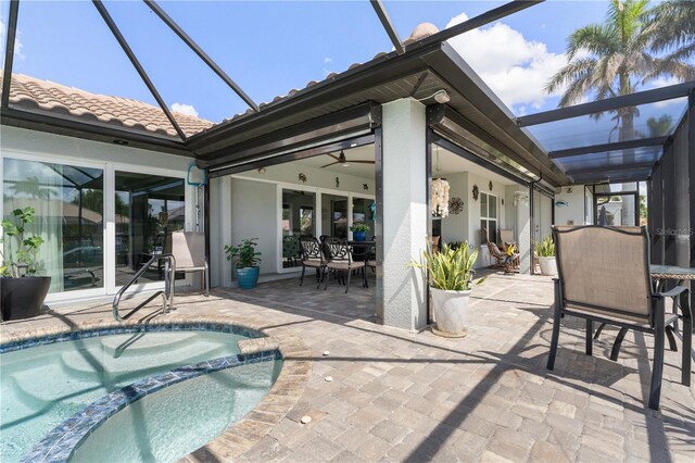 view of swimming pool with a patio, outdoor dining area, a pool with connected hot tub, and glass enclosure