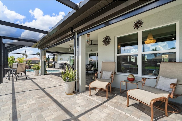 view of patio / terrace featuring glass enclosure, an outdoor pool, and a ceiling fan