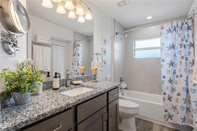 bathroom with toilet, vanity, wood finished floors, visible vents, and shower / bath combination with curtain