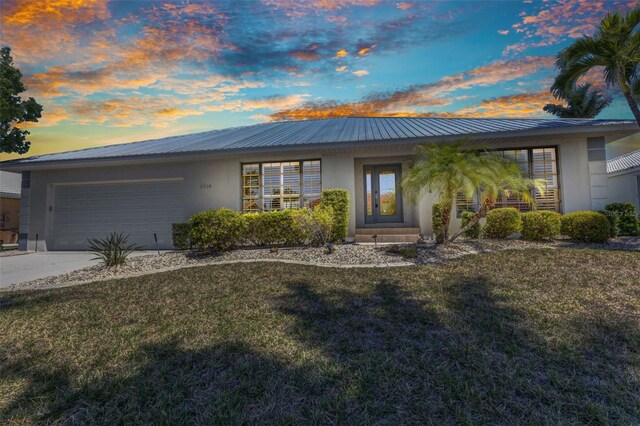 2718 Saint Thomas Dr, Punta Gorda, FL 33950 - ranch-style house featuring a garage, metal roof, a front yard, and stucco siding