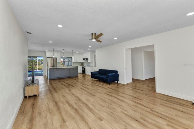 2718 Saint Thomas Dr, Punta Gorda, FL 33950 - living room with baseboards, a ceiling fan, visible vents, and light wood-style flooring