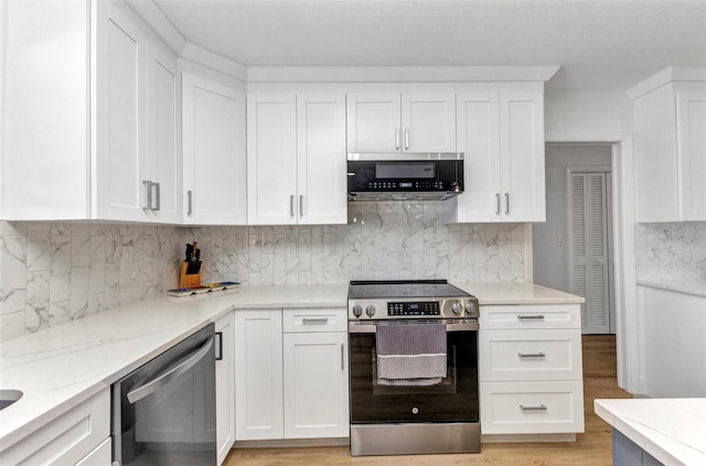 2718 Saint Thomas Dr, Punta Gorda, FL 33950 - kitchen featuring white cabinets, backsplash, light wood-style floors, light stone countertops, and appliances with stainless steel finishes