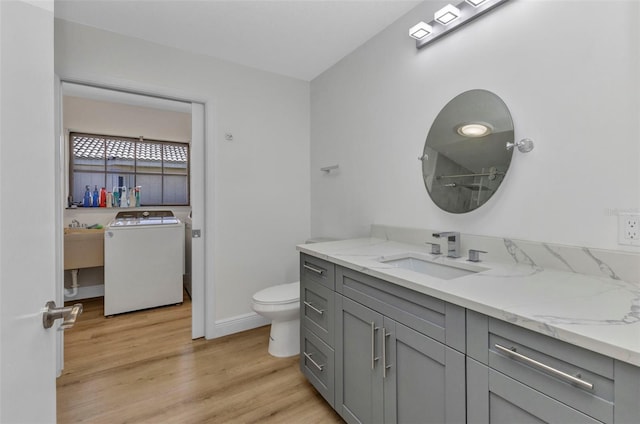 2718 Saint Thomas Dr, Punta Gorda, FL 33950 - full bath with wood finished floors, toilet, vanity, baseboards, and washer / clothes dryer
