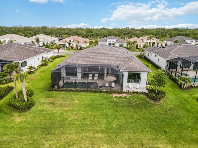 rear view of property with a yard, a lanai, and a residential view