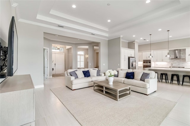 living area with a raised ceiling, ornamental molding, and light tile patterned floors