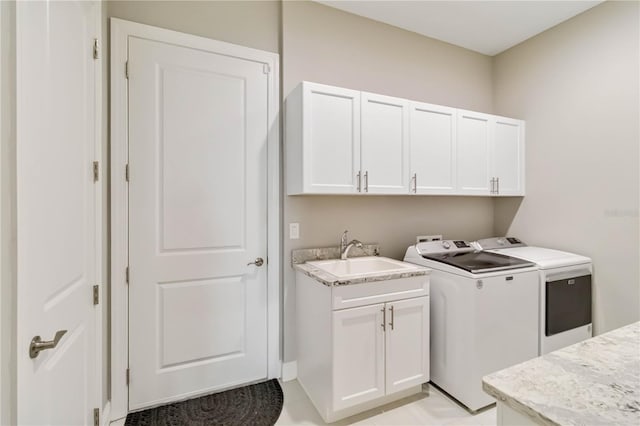 laundry area featuring independent washer and dryer, a sink, and cabinet space