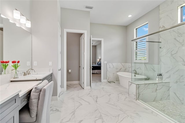 ensuite bathroom with vanity, a marble finish shower, marble finish floor, visible vents, and a freestanding bath