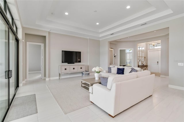 living area with baseboards, crown molding, recessed lighting, and a raised ceiling