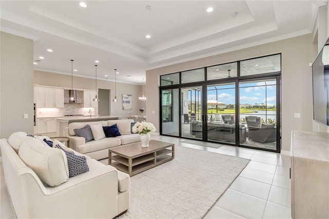 living room with a tray ceiling, crown molding, a high ceiling, light tile patterned floors, and recessed lighting