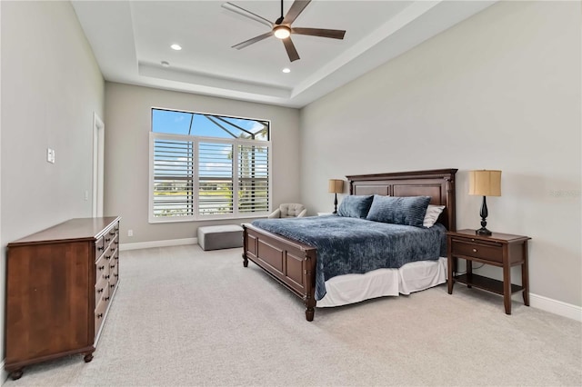 bedroom featuring a tray ceiling, baseboards, light colored carpet, and recessed lighting