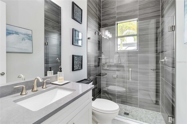 bathroom featuring vanity, toilet, and a shower stall
