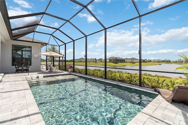 pool with a patio, a water view, and glass enclosure