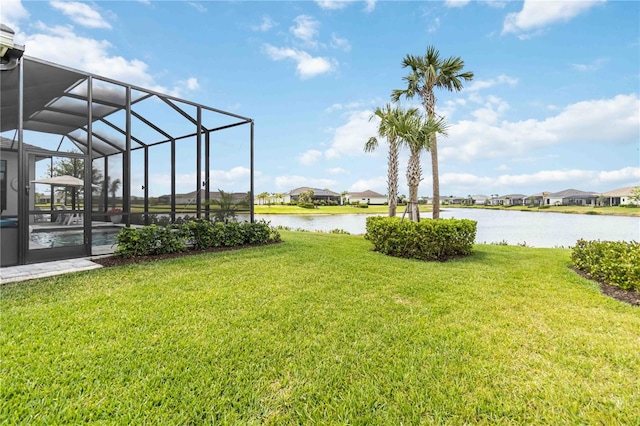 view of yard with glass enclosure and a water view