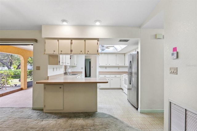 2192 Hyatt Dr, Port Charlotte, FL 33948 - kitchen with a peninsula, light countertops, freestanding refrigerator, visible vents, and a sink